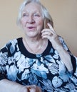 An old woman smiles and talks on a cell phone. Royalty Free Stock Photo