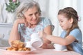 Portrait of old woman with a young girl drinking tea at home Royalty Free Stock Photo