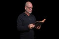 portrait of older man with beard doing reading isolated on black background Royalty Free Stock Photo