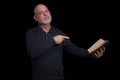 portrait of older man with beard doing reading isolated on black background Royalty Free Stock Photo