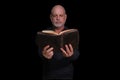 portrait of older man with beard doing reading isolated on black background Royalty Free Stock Photo