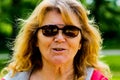 Portrait of an older women aged 60 to 70 that is wearing sunglasses outdoors. beautiful older women that is expressing