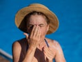 Portrait of an older woman applying sunscreen to her face while on vacation. Royalty Free Stock Photo