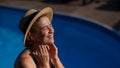Portrait of an older woman applying sunscreen to her face while on vacation. Royalty Free Stock Photo