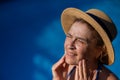 Portrait of an older woman applying sunscreen to her face while on vacation. Royalty Free Stock Photo