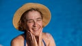 Portrait of an older woman applying sunscreen to her face while on vacation. Royalty Free Stock Photo