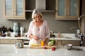 Older woman preparing food for a meal in kitchen Royalty Free Stock Photo