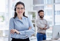 Portrait of one confident young caucasian woman standing with arms crossed while working in a call centre with her Royalty Free Stock Photo