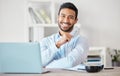 Portrait of one confident young mixed race businessman working on laptop at desk in an office. Ambitious motivated