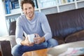 Portrait one handsome man sitting alone on the sofa in his living room, smiling and drinking coffee. Mature man feeling Royalty Free Stock Photo