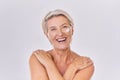 Portrait of one happy mature caucasian woman posing topless against a purple copyspace background. Ageing woman applying Royalty Free Stock Photo