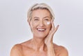 Portrait of one happy mature caucasian woman posing topless against a purple copyspace background. Ageing woman applying Royalty Free Stock Photo