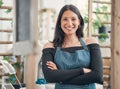 Portrait of one happy young hispanic waitress standing with her arms crossed in a store or cafe. Friendly woman and Royalty Free Stock Photo