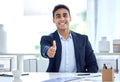 Portrait of one happy young mixed race business man gesturing thumbs up for success and agreement in an office Royalty Free Stock Photo