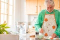 Portrait of one mature and old man cooking at home in the kitchen smiling. Senior preparing food to lunch alone indoor. Retired