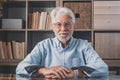 Portrait of one old cheerful male senior smiling having fun at home. Mature caucasian man studying independent looking at the Royalty Free Stock Photo