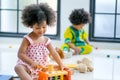 Portrait of one young African mixed race girl is playing with toys in front of the other african boy and look like she enjoy and Royalty Free Stock Photo