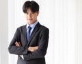 Portrait one young asian businessman who smart and handsome wearing black suit standing look at camera while smiling and folded