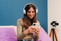 Portrait of one young happy caucasian woman having fun listening music using a smartphone app on internet with wireless Royalty Free Stock Photo