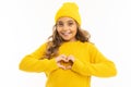 Portrait of european attractive girl in yellow clothes shows a heart with her hands on a white background with copyspace