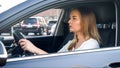 Portrait through open car window of young concentrated woman driving a car Royalty Free Stock Photo