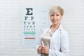 Portrait of ophthalmologist staying in front of visual inspection table.