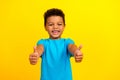 Portrait of optimistic nice schoolboy with afro hair wear blue t-shirt showing thumbs up good work isolated on vivid Royalty Free Stock Photo