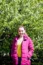 Portrait of a ordinary cute girl in the green park full of blossoming apple tree with white flower in a springtime Royalty Free Stock Photo