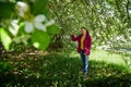 Portrait of a ordinary cute girl in the green park full of blossoming apple tree with white flower in a springtime Royalty Free Stock Photo