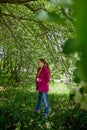 Portrait of a ordinary cute girl in the green park full of blossoming apple tree with white flower in a springtime Royalty Free Stock Photo