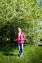 Portrait of a ordinary cute girl in the green park full of blossoming apple tree with white flower in a springtime Royalty Free Stock Photo