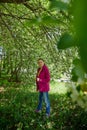 Portrait of a ordinary cute girl in the green park full of blossoming apple tree with white flower in a springtime Royalty Free Stock Photo