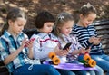 Portrait of ordinary kids playing with phones