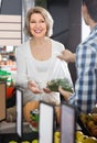 Portrait of ordinary mature woman buying green pepper in grocery Royalty Free Stock Photo