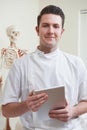 Portrait Of Osteopath In Consulting Room With Digital Tablet Royalty Free Stock Photo
