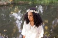 Portrait outdoors of a beautiful young afro american woman at sunset. Green background. Lifestyle. Wearing jeans casual summer Royalty Free Stock Photo