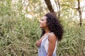 Portrait outdoors of a beautiful young afro american woman at sunset. Green background. Lifestyle. Wearing jeans casual summer Royalty Free Stock Photo