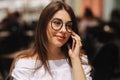 Portrait of outgoing lady telling by phone and waiting waiter. She looking at the street. Business and rest concept Royalty Free Stock Photo