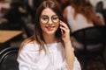 Portrait of outgoing lady telling by phone and waiting waiter. She looking at the street. Business and rest concept Royalty Free Stock Photo