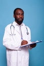 Portrait of overconfident doctor looking at camera holding clipboard