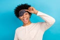Portrait of overjoyed positive man open one eye blindfold mask have good mood isolated on blue color background Royalty Free Stock Photo