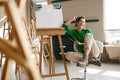 Portrait of overjoyed smiling woman artist holding paintbrush on nose Royalty Free Stock Photo