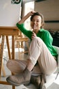 Portrait of overjoyed smiling woman artist holding paintbrush on nose