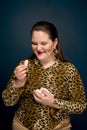 Portrait of a overweight girl with sweets in her hands. Leopard blouse.