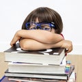 Portrait, overwhelmed intellectual child hiding behind on pile of books
