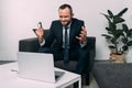 portrait of overworked businessman with eyeglasses looking at laptop on coffee table Royalty Free Stock Photo