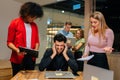 Portrait of overworked team leader under stress sitting at table with laptop holding pain head. Female multiethnic Royalty Free Stock Photo