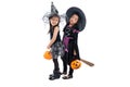 Portrait pair of little girls in Halloween and carnival costume ride the wooden broom isolated on white background Royalty Free Stock Photo