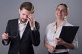 Portrait of a pair of young business people The man sadly takes off his glasses,holds his head in his hand, next to a young