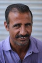 Portrait of a Pakistani middle-aged male with a mustache smiling